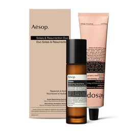 Un frasco con dosificador de Solais Replenishing Hand Serum y un tubo de Resurrection Aromatique Hand Balm, presentados juntos en una caja  de carton.