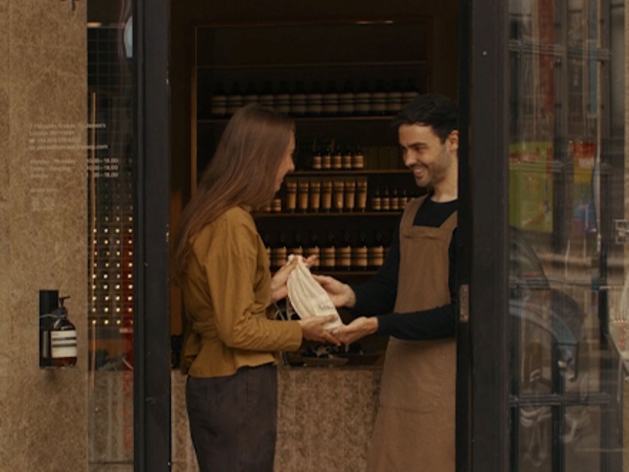 Una consulta de cuidado de manos en una tienda Aesop, junto a un tubo de 15 mL de Eleos Aromatique Hand Balm de regalo al suscribirte a nuestras comunicaciones.