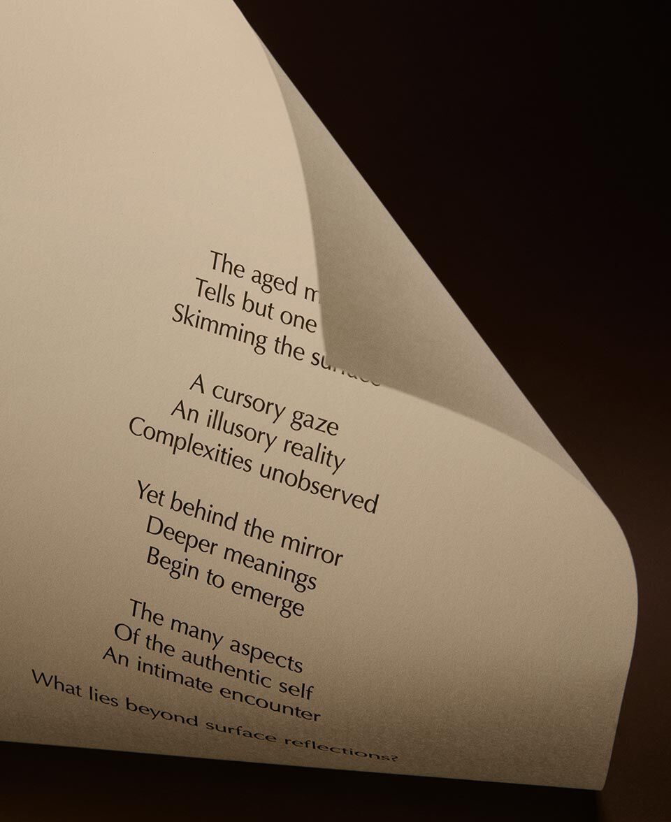 Papel crema doblado con versos impresos, en un entorno oscuro y minimalista.