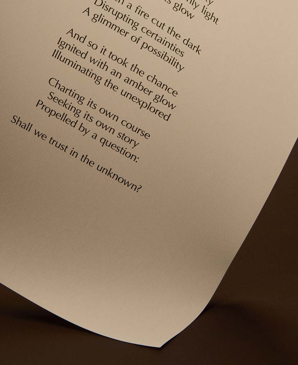 Pagina curvada con texto de poema impreso sobre un calido fondo marron oscuro.