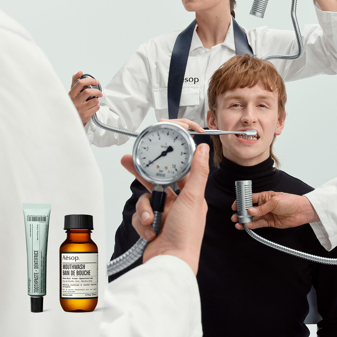Escena clinica surrealista de cuidado bucal con productos de la marca Aesop.