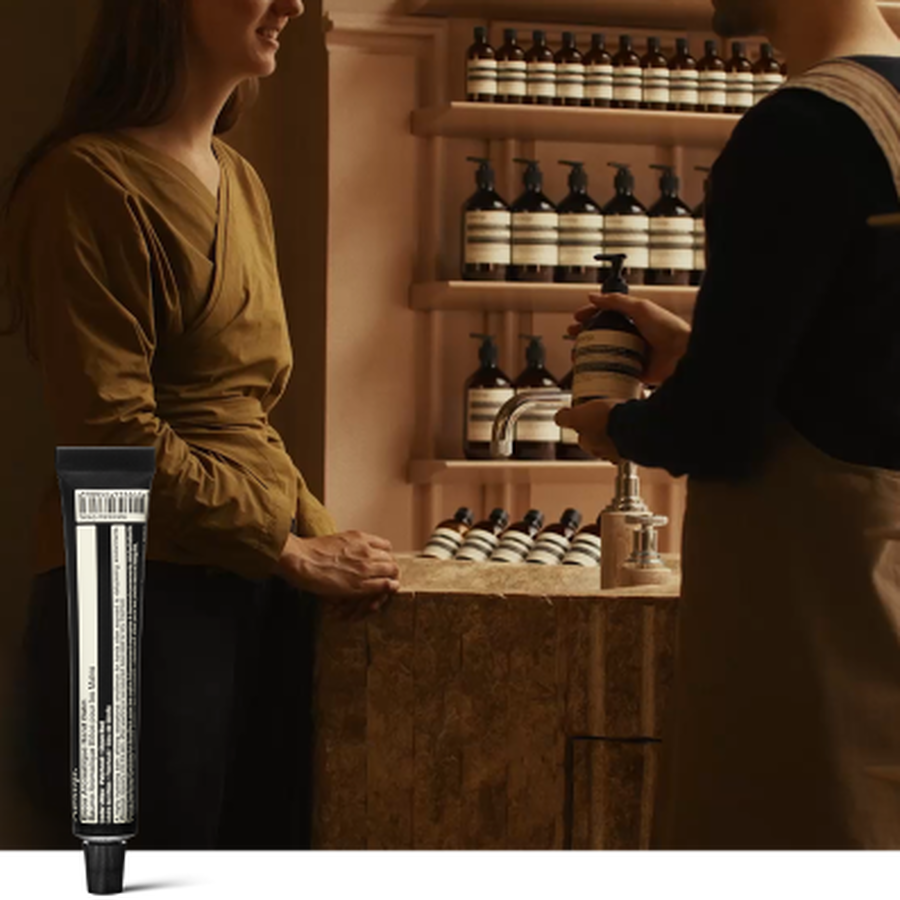 Una consulta de cuidado de manos en una tienda Aesop, junto a un tubo de 15 mL de Eleos Aromatique Hand Balm de regalo al suscribirte a nuestras comunicaciones.