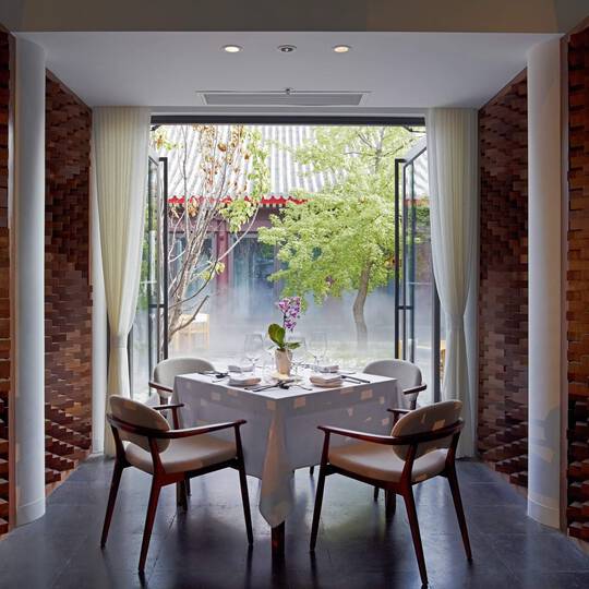 A dining table in front of a floor-to-ceiling window.