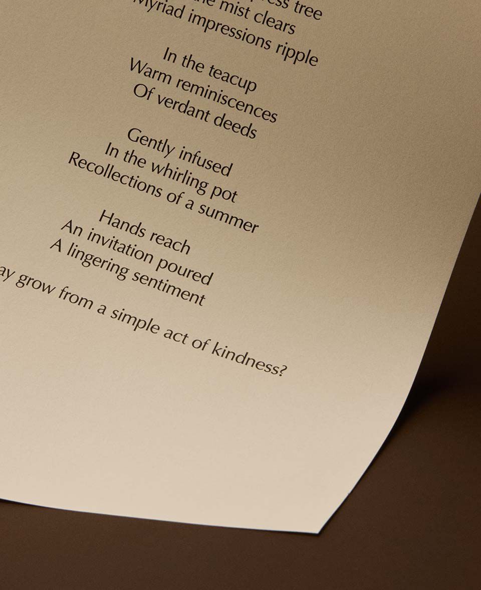 Versos de un poema centrados sobre una pagina curva color crema, sobre un fondo marron calido.