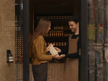 Una consulta de cuidado de manos en una tienda Aesop, junto a un tubo de 15 mL de Eleos Aromatique Hand Balm de regalo al suscribirte a nuestras comunicaciones.