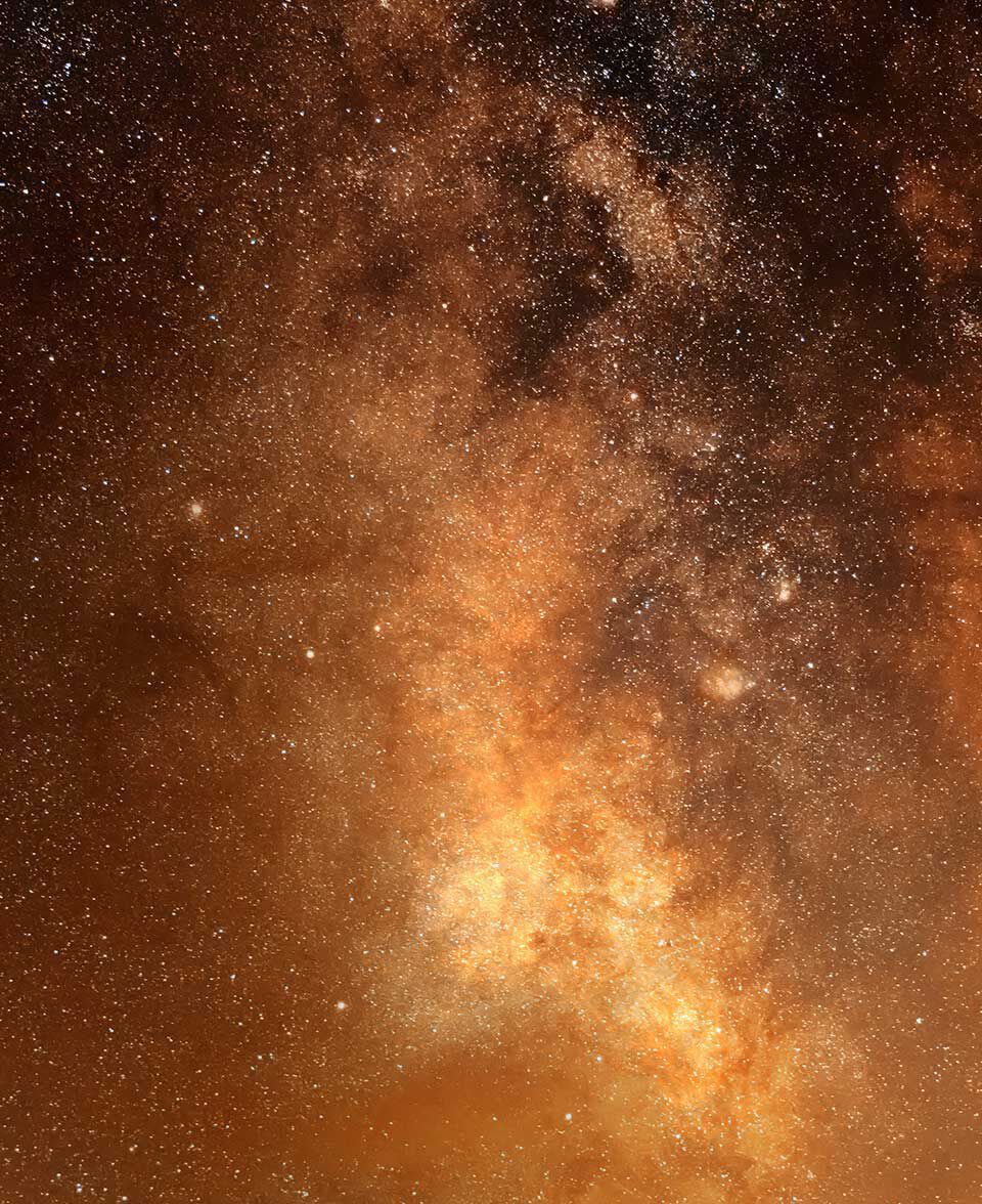 Denso campo de estrellas en calidos tonos ambar y dorados a traves del cielo nocturno.